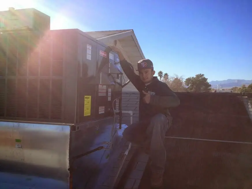 HVAC technician performing AC Tune-Up on a rooftop unit in Lorain